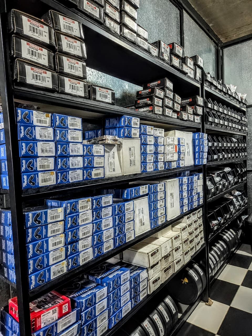Estanterías repletas de cajas de productos apiladas de color azul, blanco y rojo en un pasillo de la tienda.