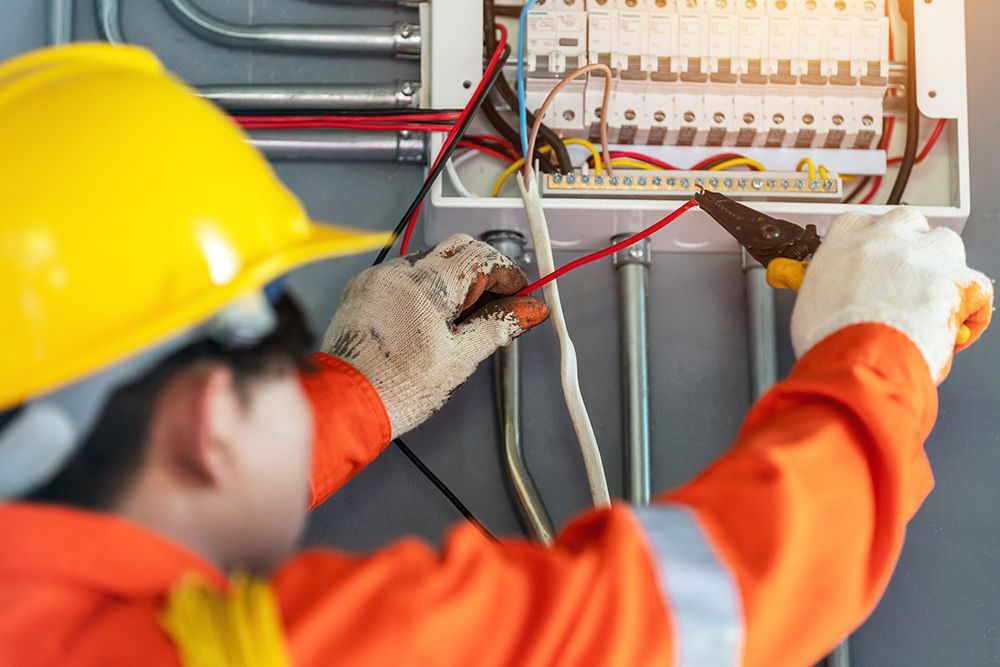 An electrician is working on an electrical box.
