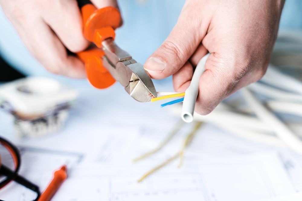 A person is cutting a wire with a pair of pliers.