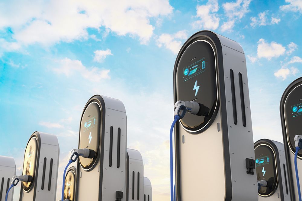A row of electric cars are being charged at a charging station.