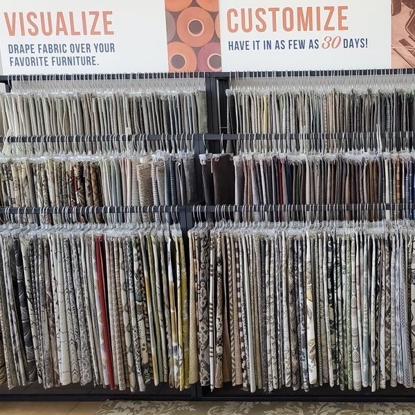 Fabric swatch display shelves with “Visualize” and “Customize” signs at a furniture store