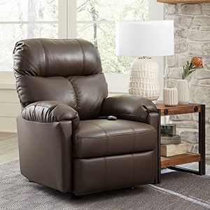 Brown leather recliner beside a wooden side table and lamp in a bright living room