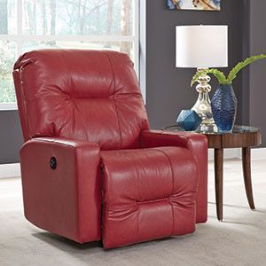 Red leather recliner beside a wooden side table with lamp and vases in a living room.