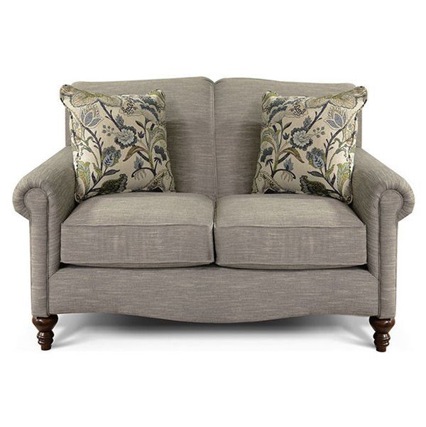 Beige upholstered loveseat with floral throw pillows and dark wooden legs