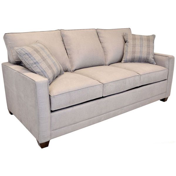Beige upholstered sofa with two plaid accent pillows on a white background