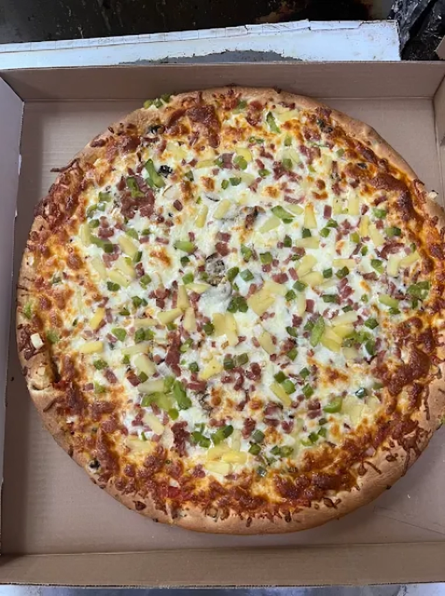 A pizza with tomatoes and basil on a wooden cutting board