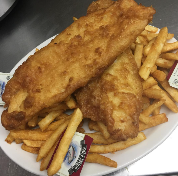 A white plate topped with fish and french fries