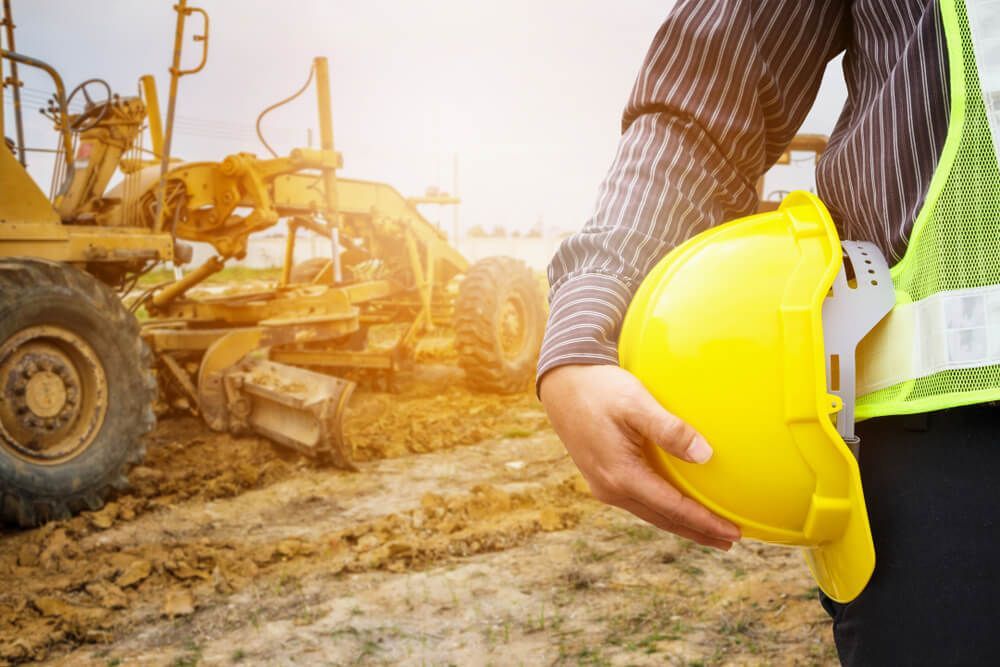 Worker Holding Yellow Safety Helmet — Civil Contractors in Coopernook, NSW