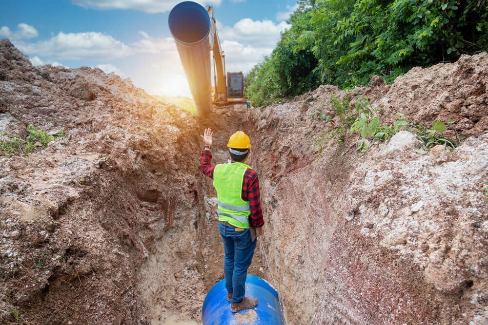 Construction Worker Guiding Pipe Layering — Civil Contractors in Laurieton, NSW