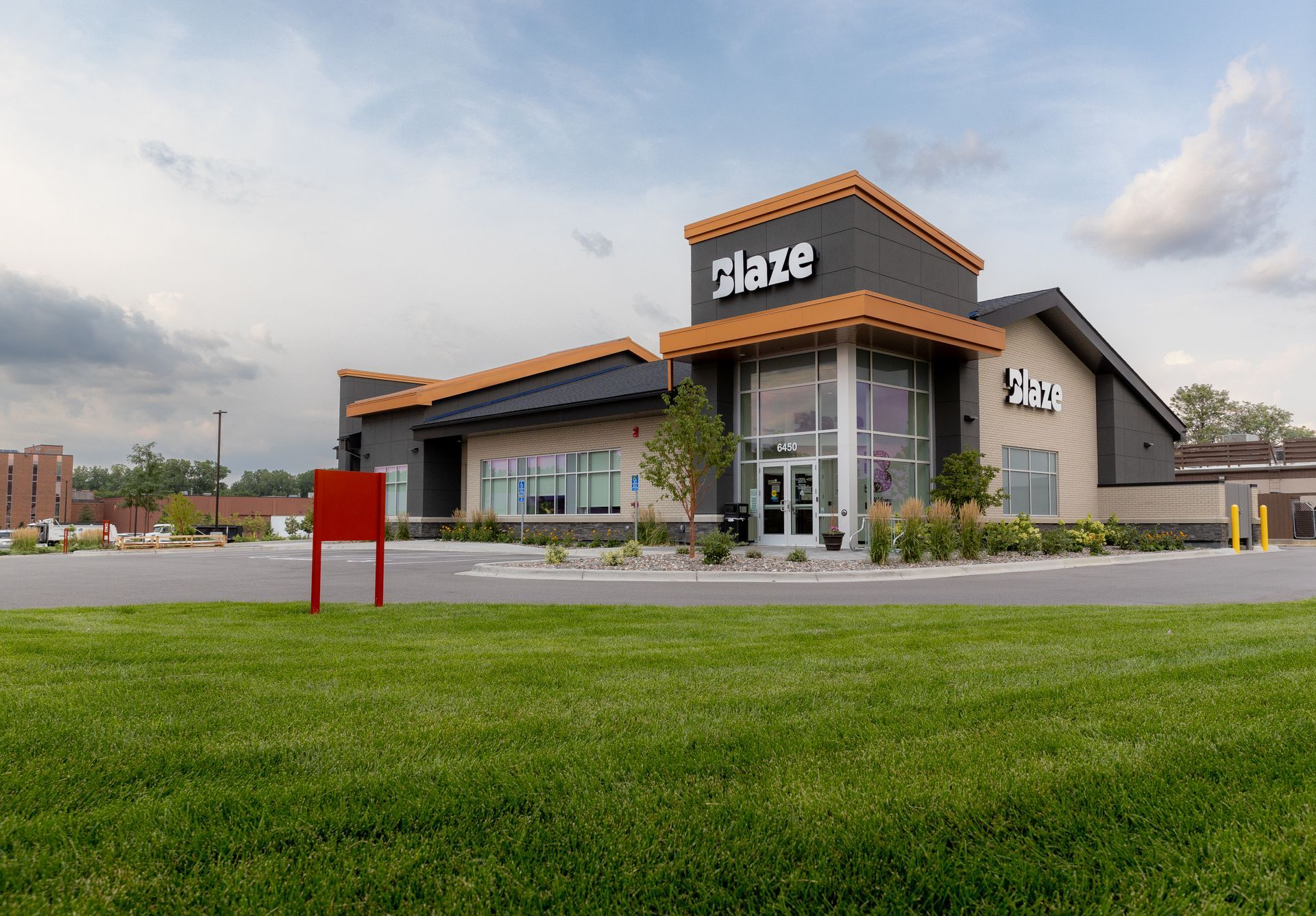 A commercial building sitting on top of a lush green field.