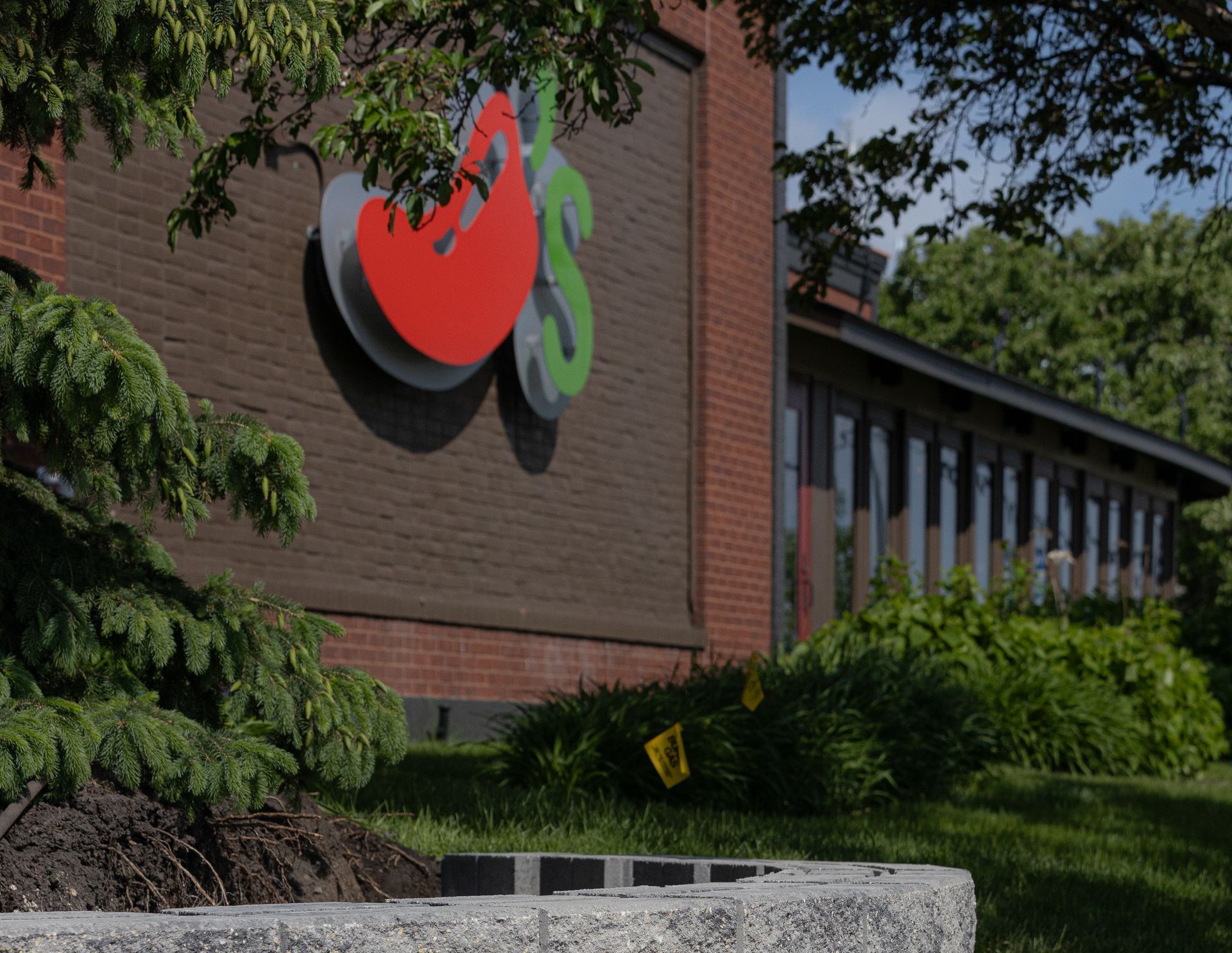 A brick building with a red and green logo on it