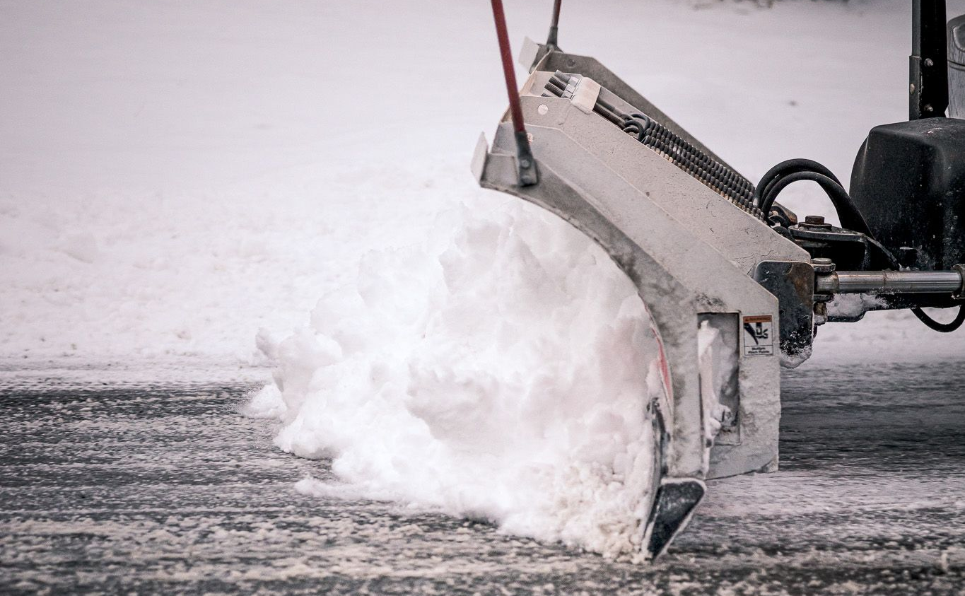 Snowplow clearing snow from a road.