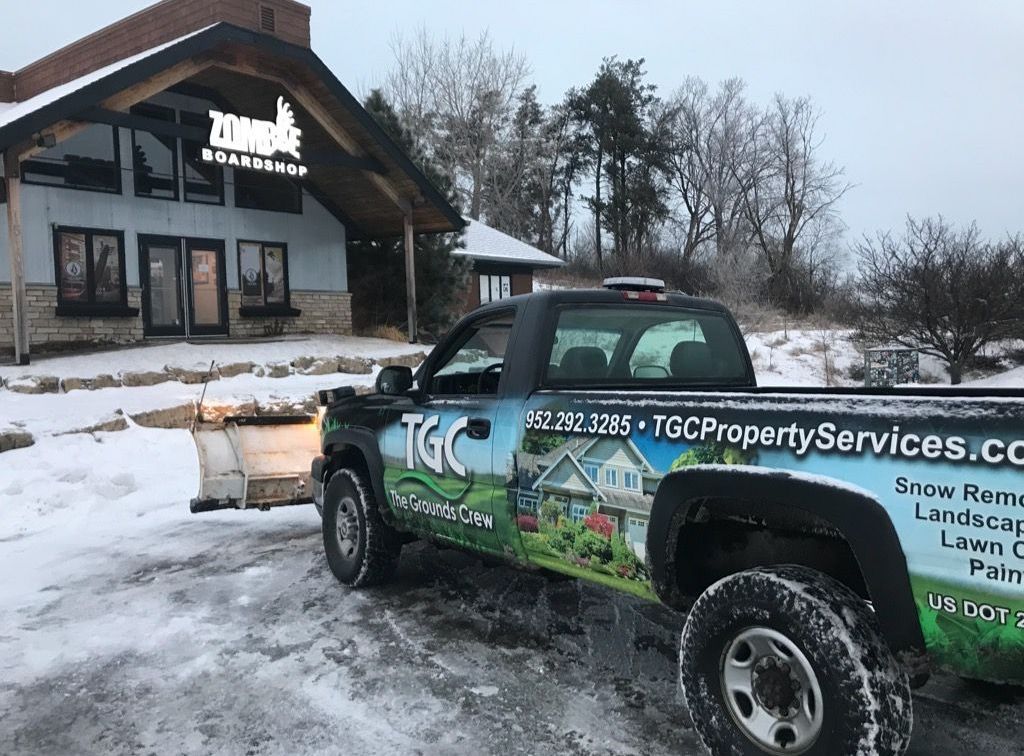 A truck is parked in the snow in front of a building
