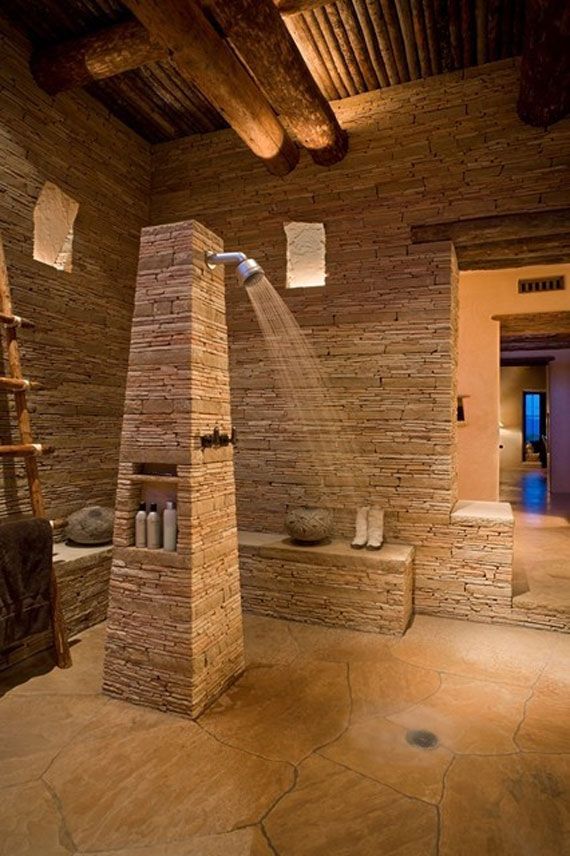 A bathroom with a brick wall and a walk in shower
