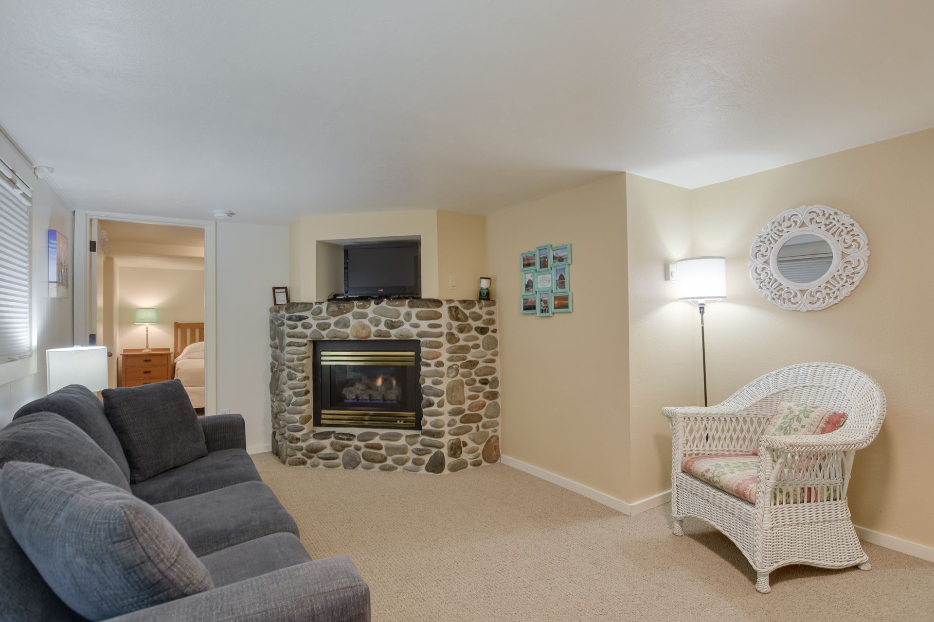 A living room with a couch , chair , fireplace and television.