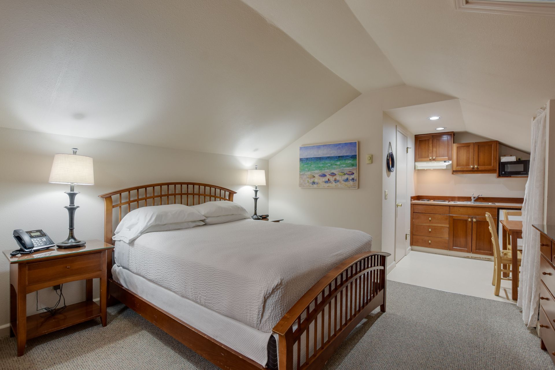 A bedroom with a king size bed and a kitchen.