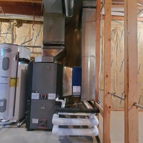 Basement utility room with furnace, water heater, ductwork, and exposed wooden framing
