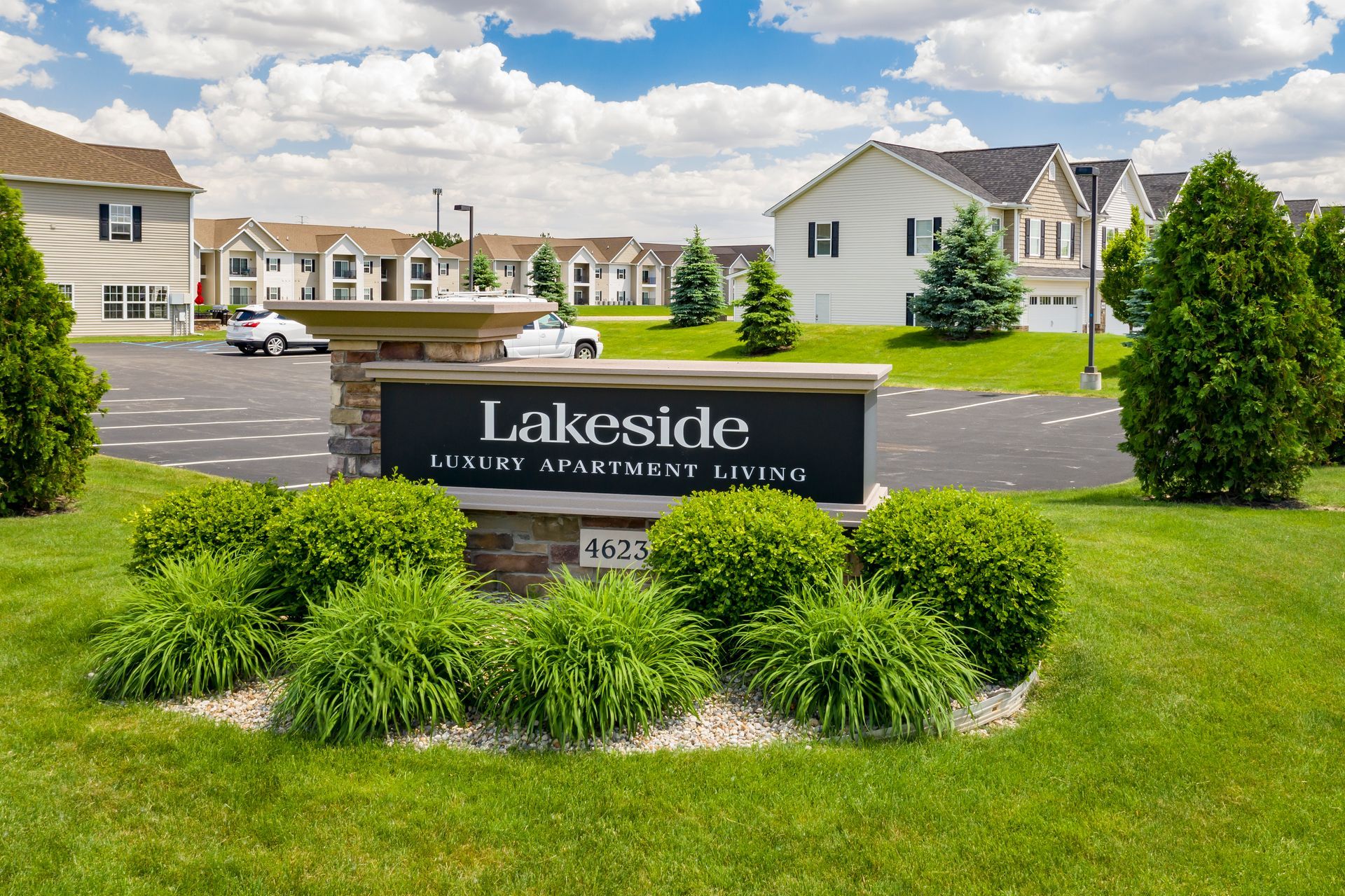 Sign for Lakeside Luxury Apartment Living with apartments and landscaping in the background.