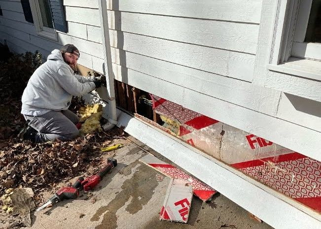 Leaking water heater, rust-colored streaks running down its side in an enclosed room.