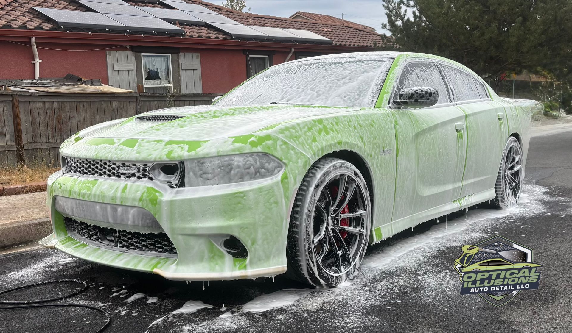 Gloved hands polishing a glossy red car with a white cloth and small applicator brush
