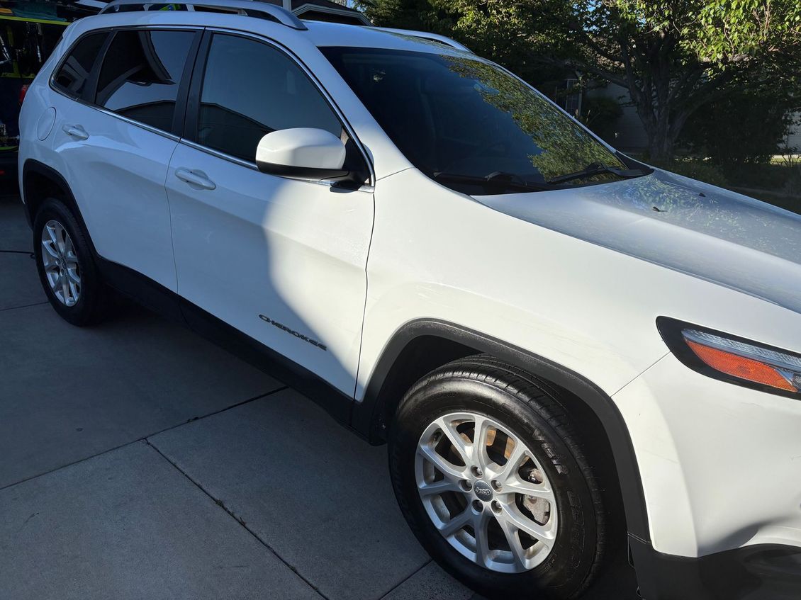 White SUV parked in a driveway, shown from the front-left side.