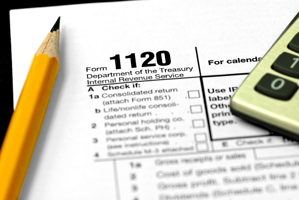 A calculator and pencil on top of a form 1120