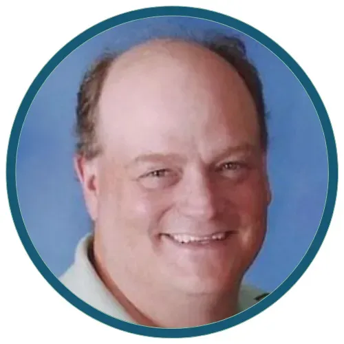Smiling bald man in a circular headshot with a blue background and teal border