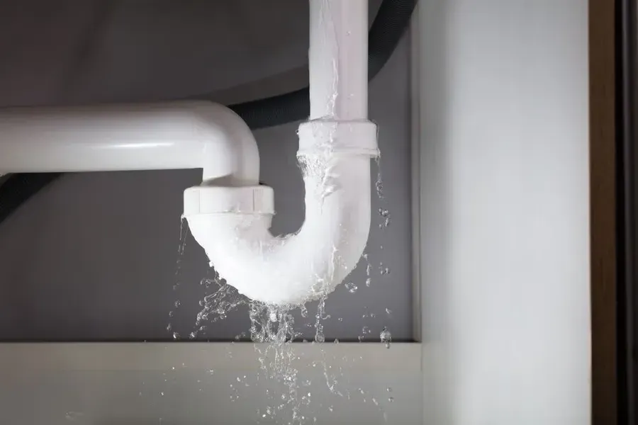 Leaking White Plumbing Pipes With Water Splashing — Phil Lindfield's Big Red Carpet Cleaning In Harrington, NSW