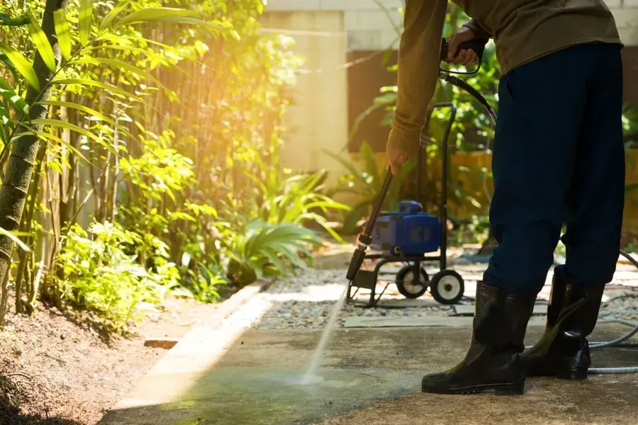 Person Pressure Washing a Concrete Walkway Outdoors — Phil Lindfield's Big Red Carpet Cleaning In Harrington, NSW