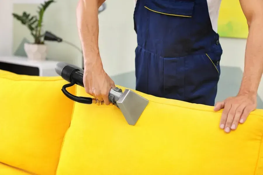 Person Cleaning a Bright Yellow Sofa — Phil Lindfield's Big Red Carpet Cleaning In Old Bar, NSW
