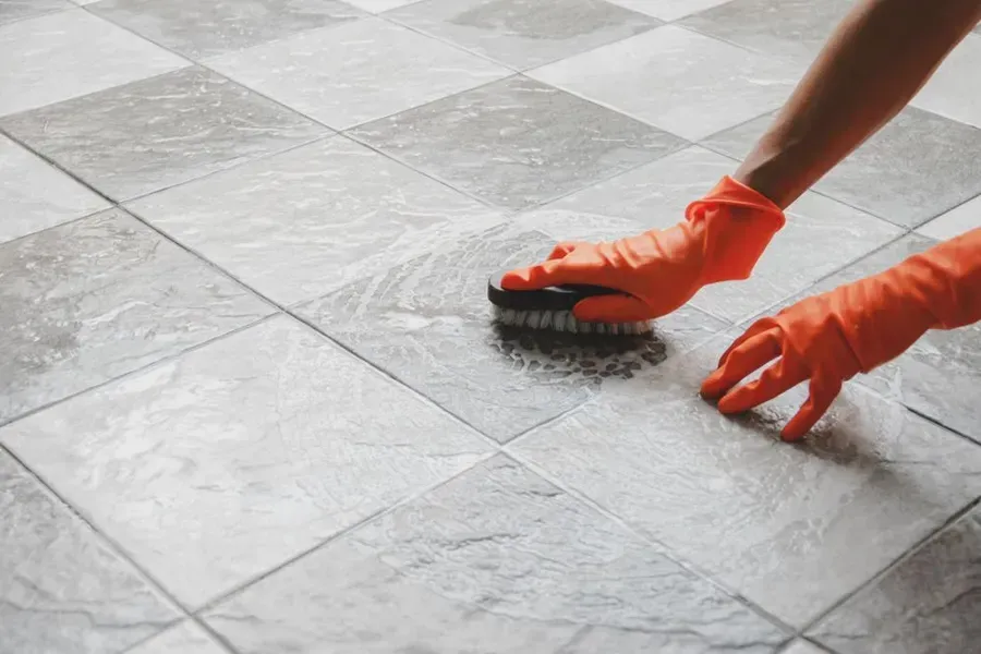 Person Wearing Orange Gloves Scrubbing — Phil Lindfield's Big Red Carpet Cleaning In Tuncurry, NSW