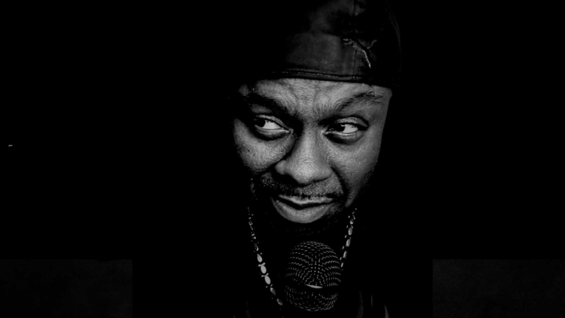 Ty Burnz with microphone, black and white portrait