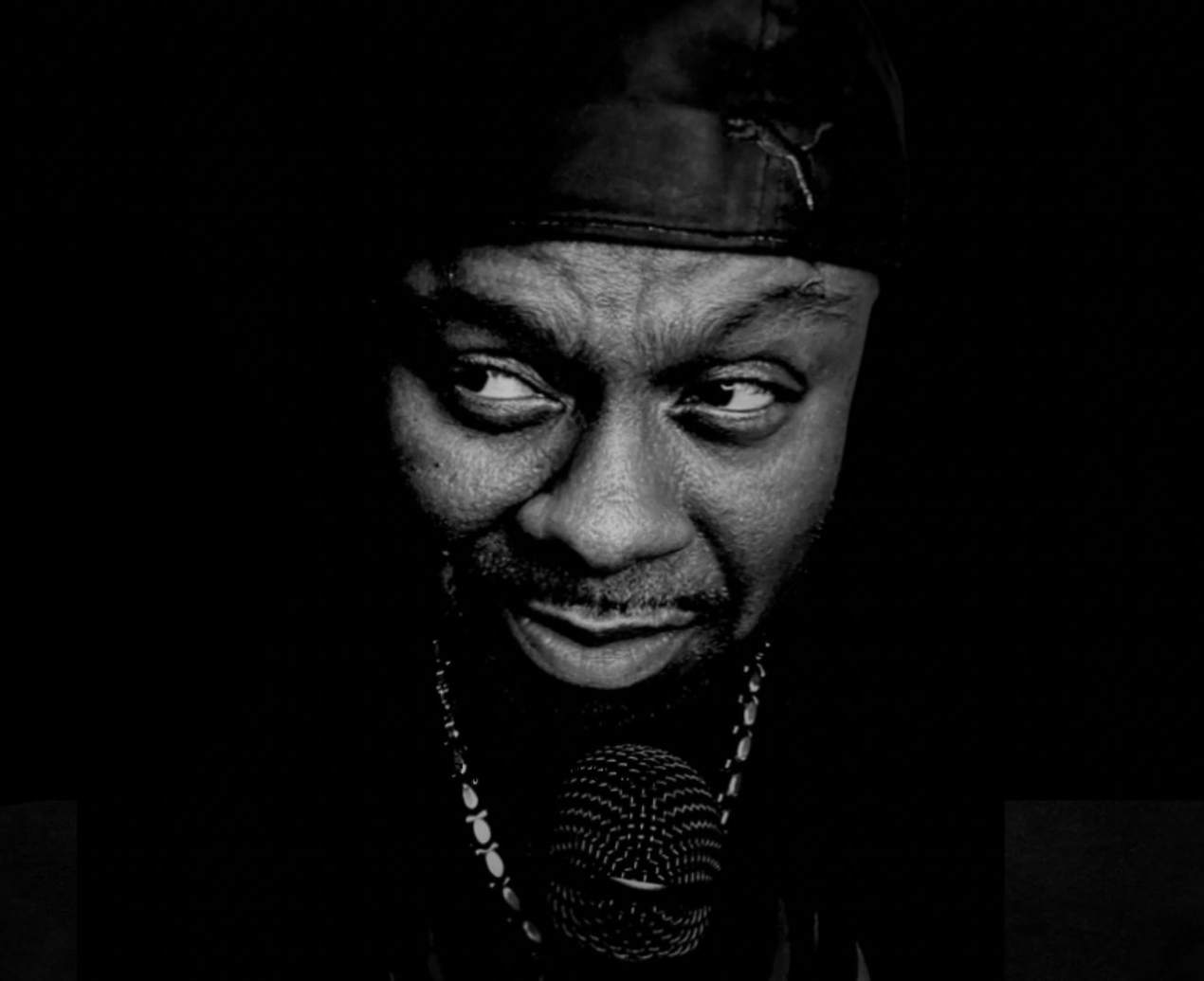 Ty Burnz holding microphone, high contrast black and white editorial portrait