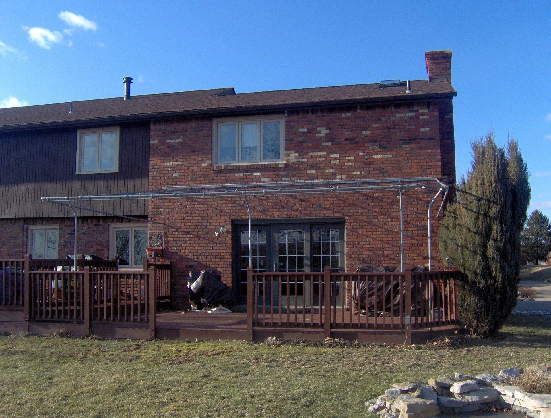 A brick house with a wooden deck in front of it