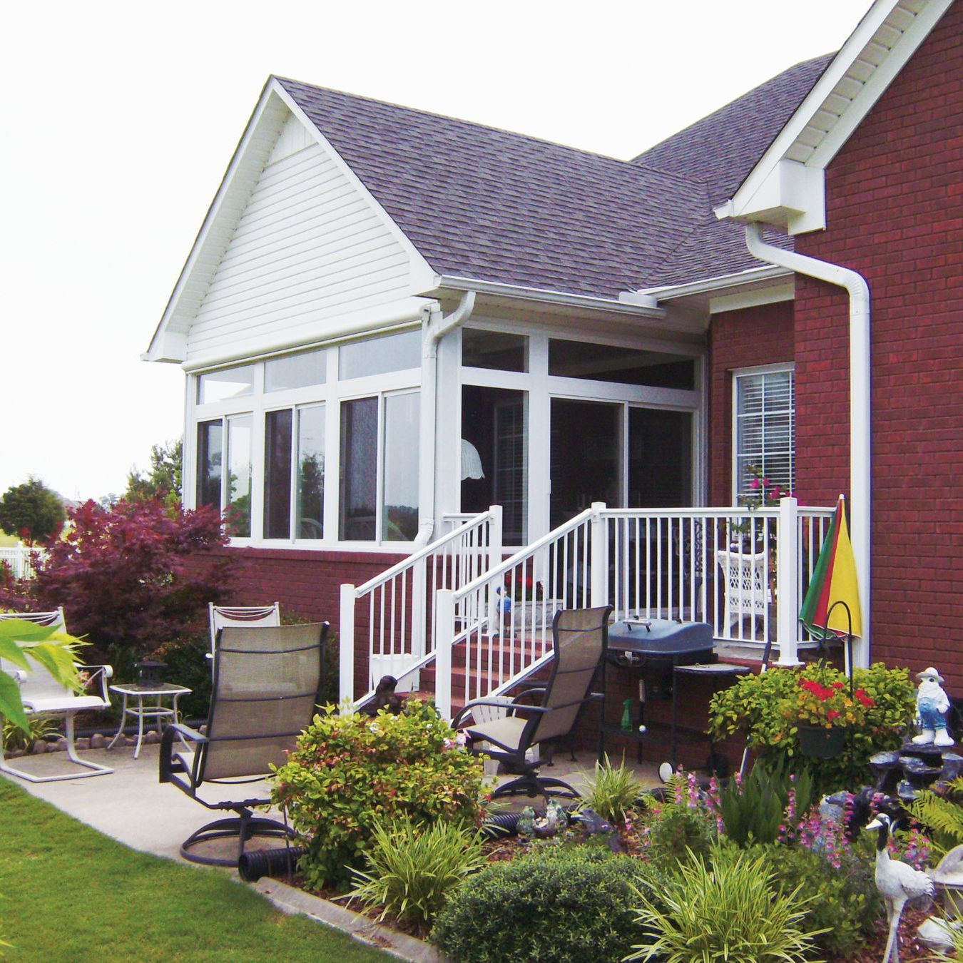 A red brick house with a white railing and stairs