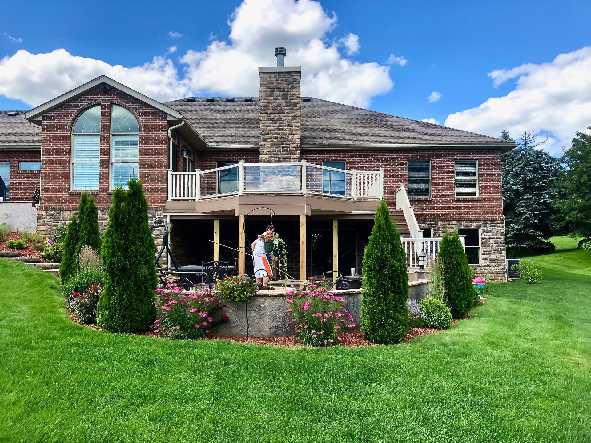 A large brick house with a large deck in front of it