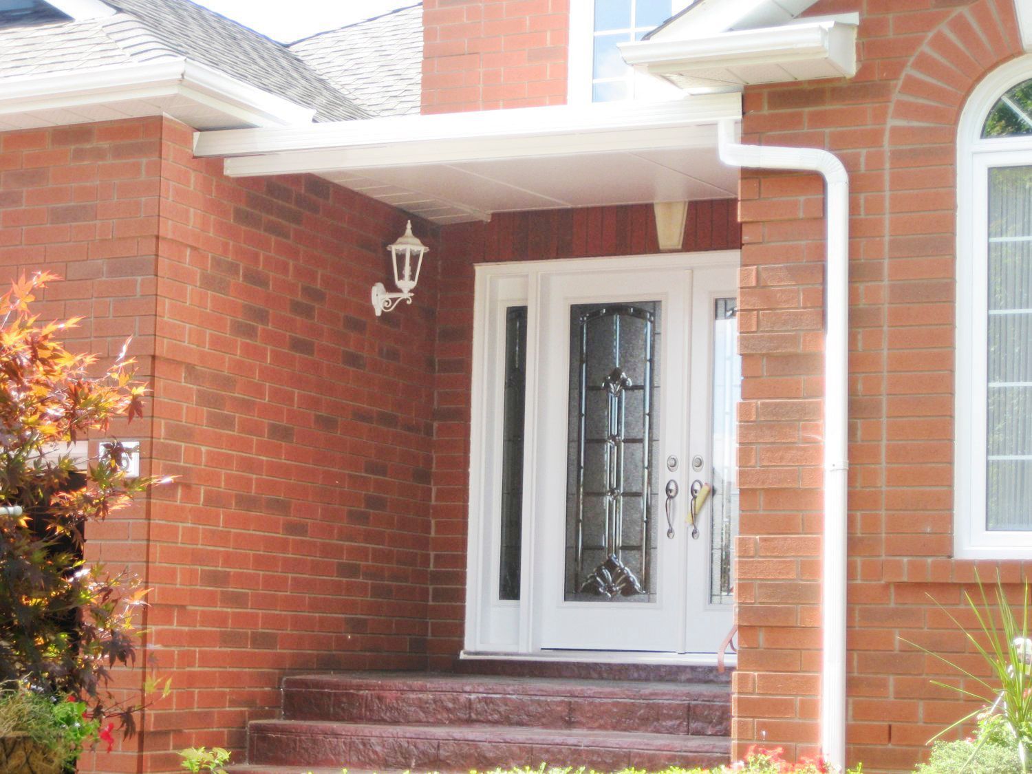 A red brick house with a white door and stairs