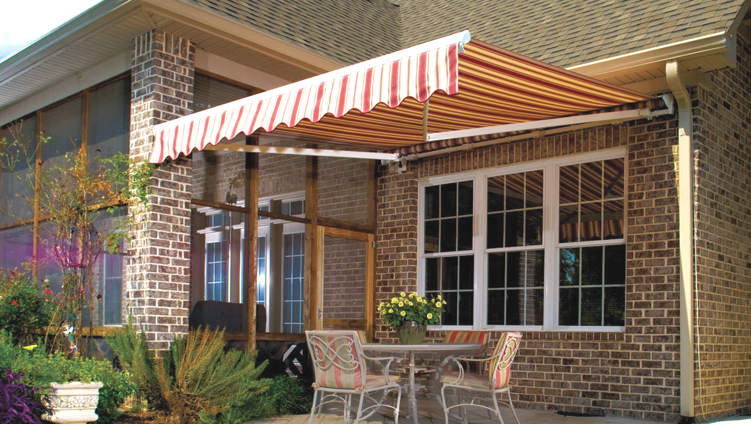 A brick house with a table and chairs under an awning