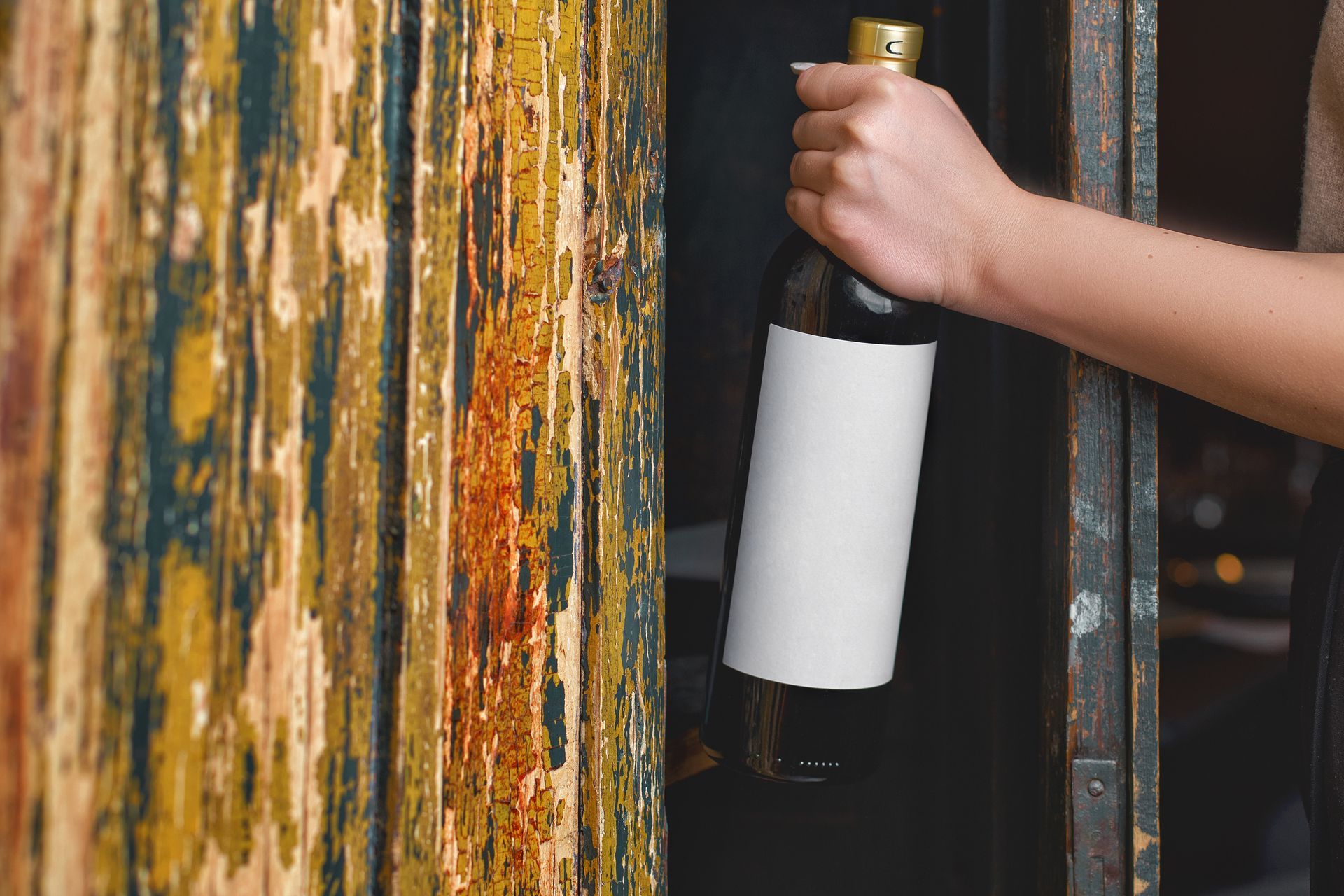 a woman is holding a bottle of wine in her hand .