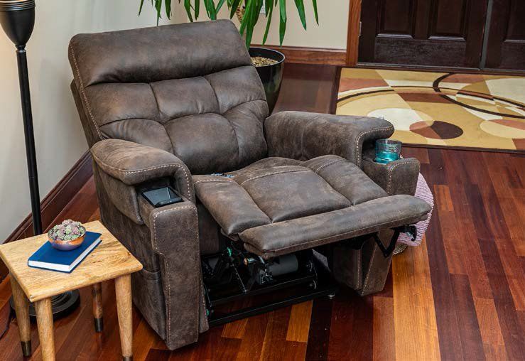 A brown recliner is sitting on a wooden floor in a living room.