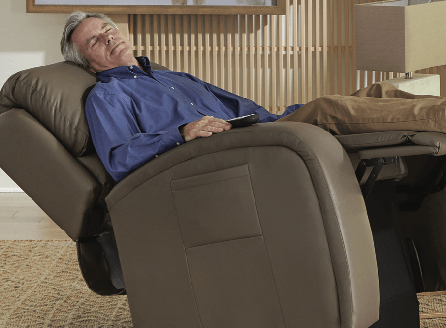 A man is sleeping in a recliner in a living room.