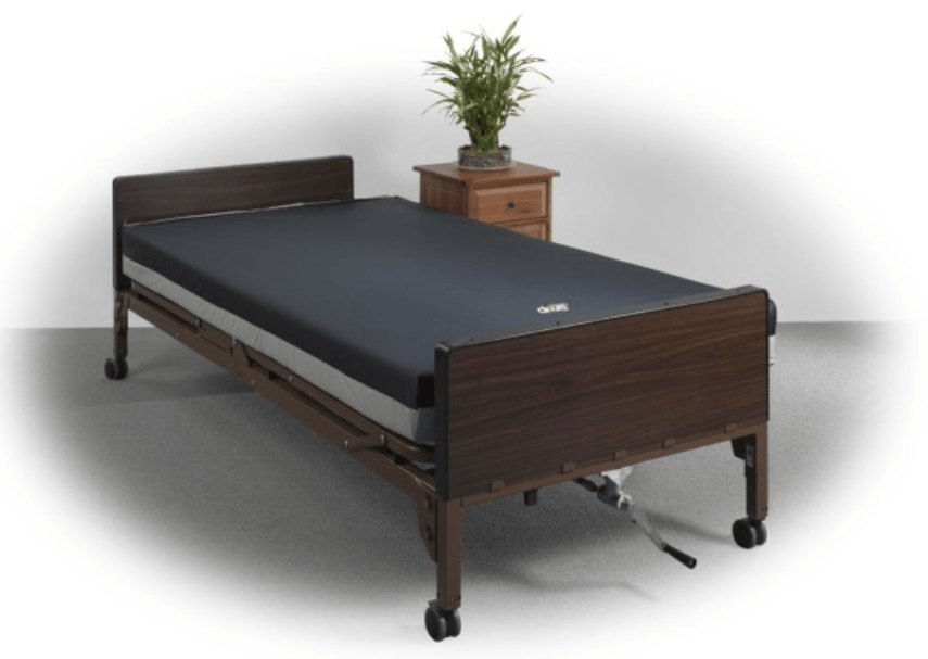 A hospital bed with a black mattress and a plant on a nightstand