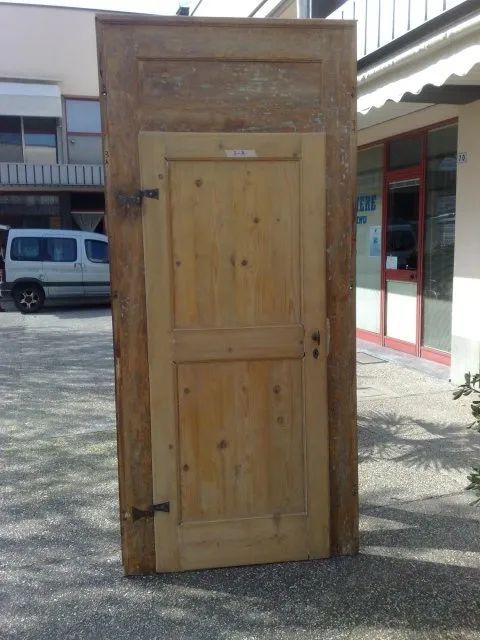 Una grande porta di legno è posta di fronte a un edificio