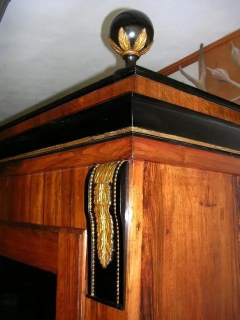 Un angolo di un mobiletto di legno con una palla nera in cima