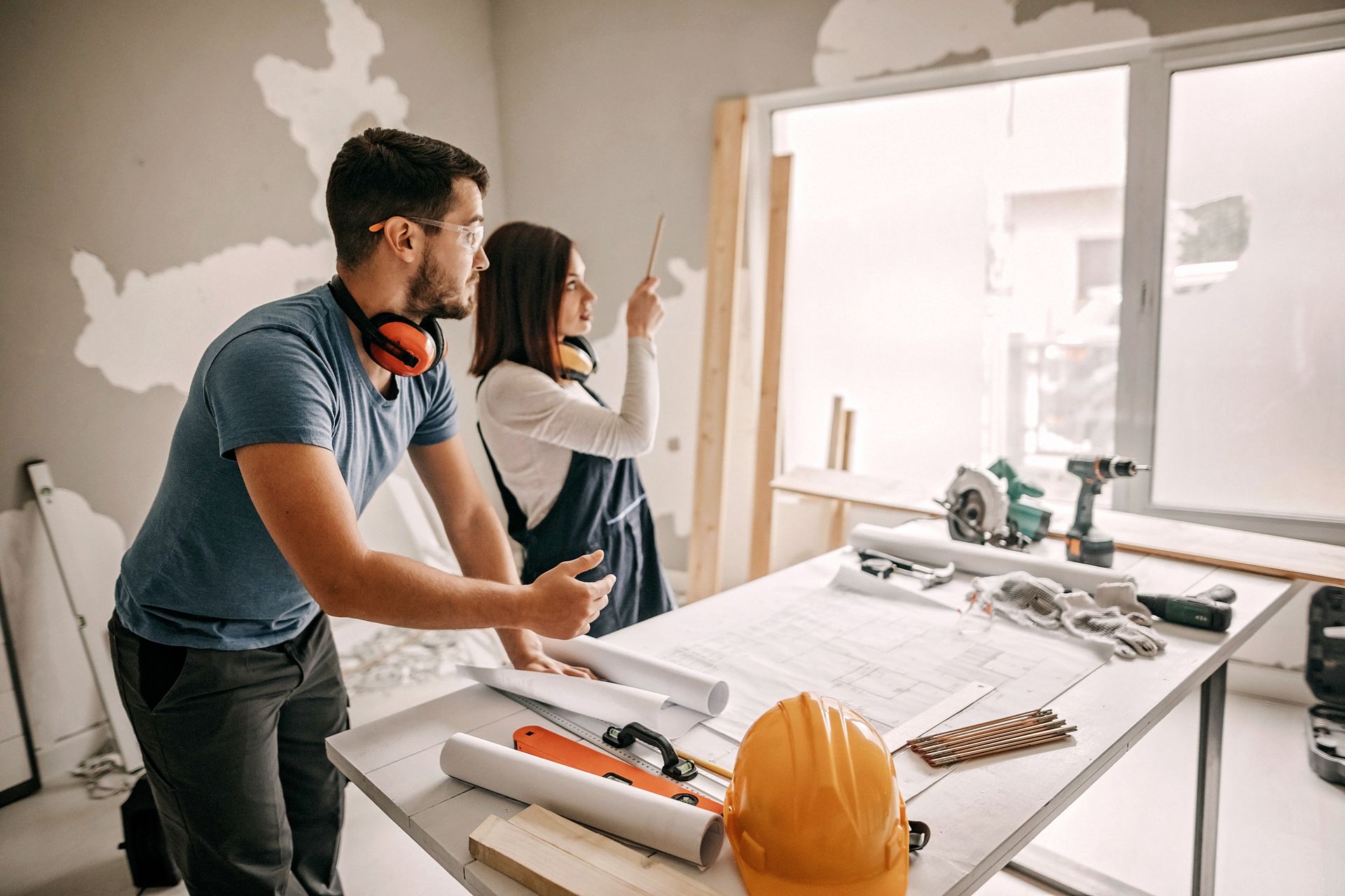 A man and a woman are standing next to a table in a room. A man and a woman are standing next to a table in a room.
