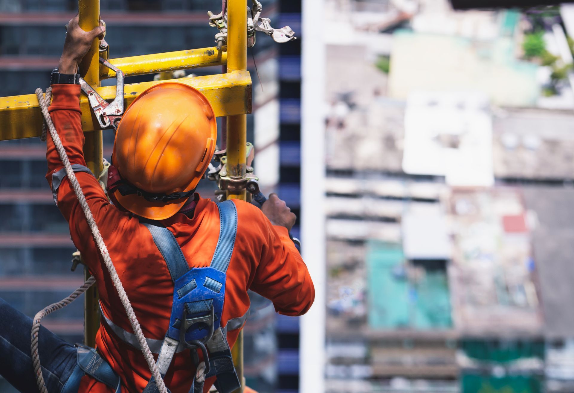 A construction worker is climbing a ladder on top of a building. A construction worker is climbing a ladder on top of a building.