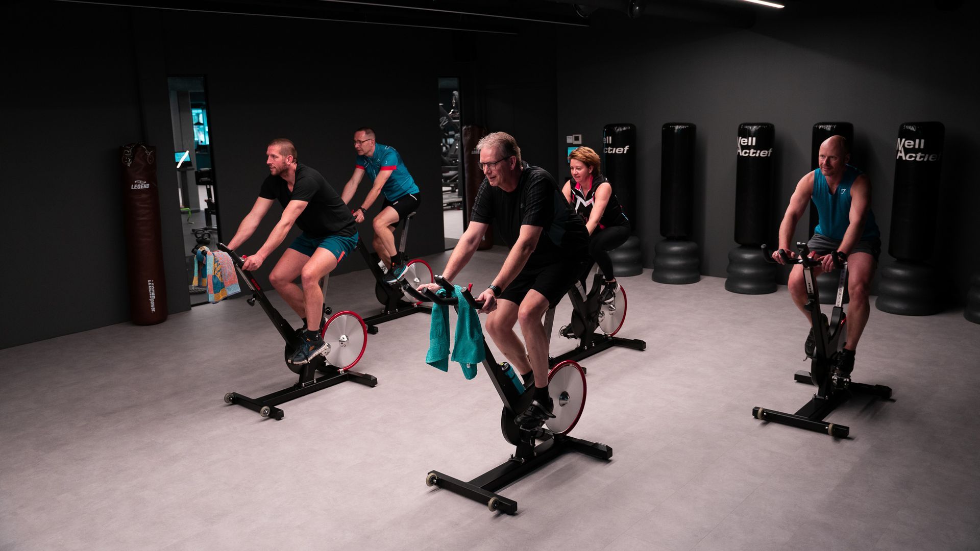 Mensen die fietsen op hometrainers in een sportschool.