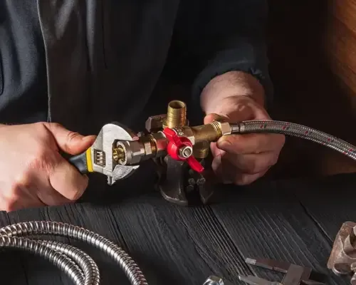 a plumber works on hose connections