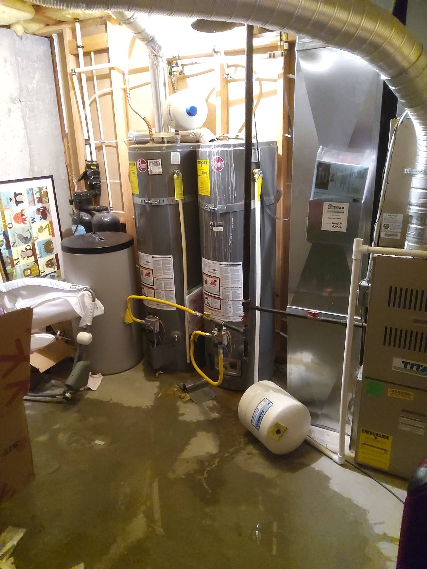 Utility room with water heater, HVAC equipment, and a flooded floor.