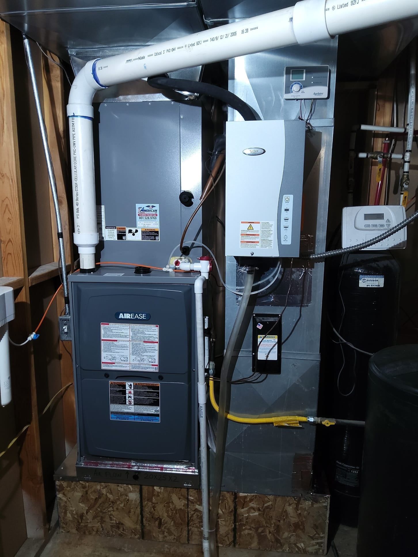 Furnace and HVAC equipment in a basement utility room with exposed ducts and pipes.